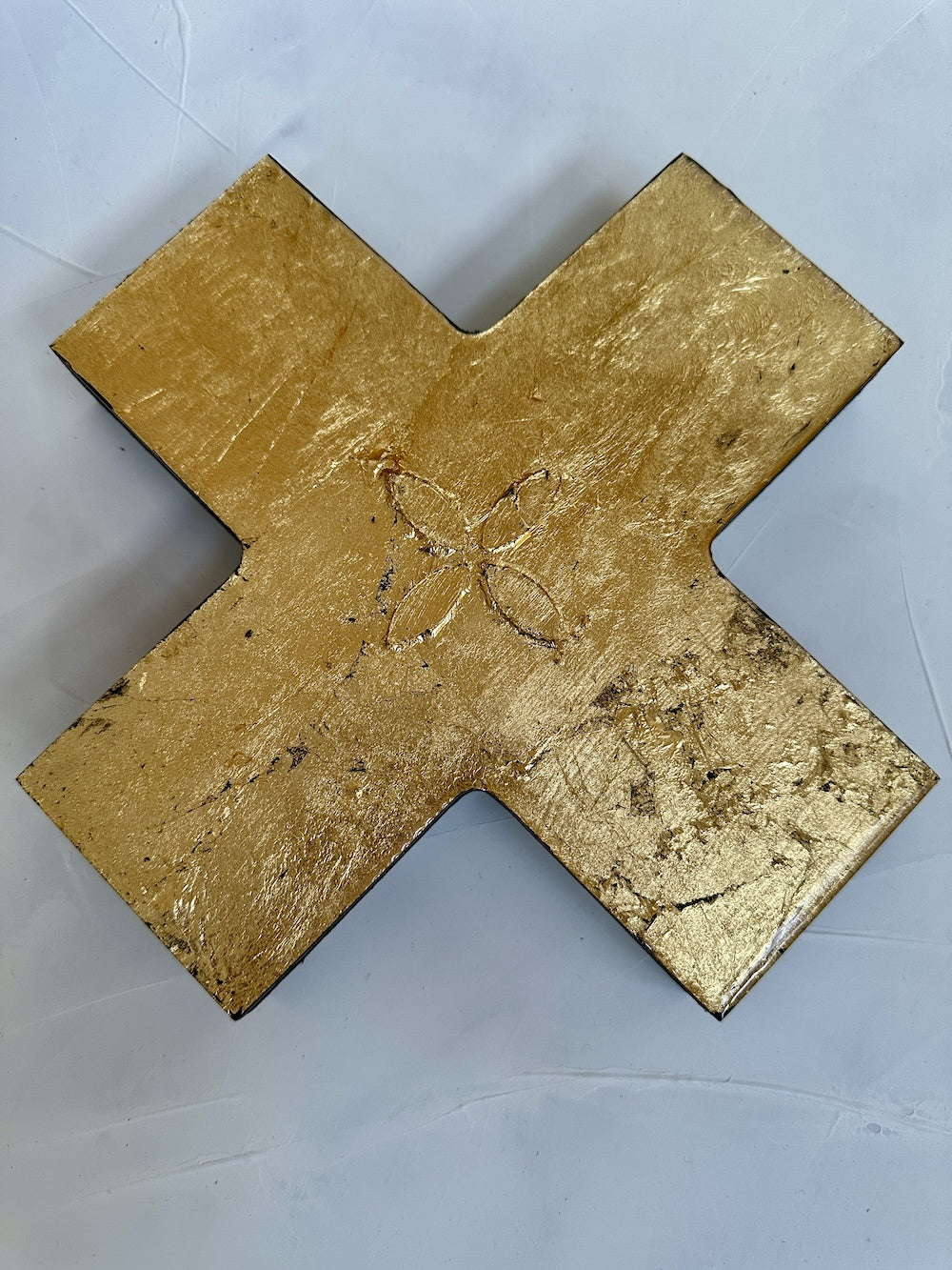 Gold-colored metal cross on a white background